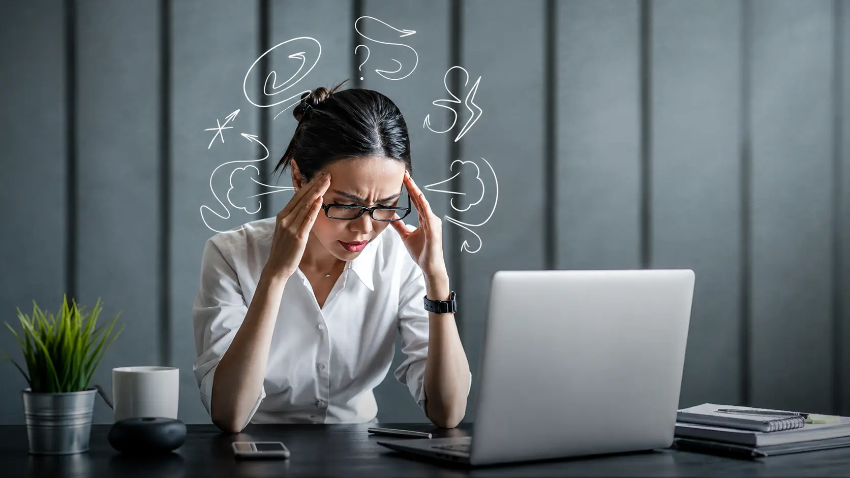 Perfect | Stressed professional woman holding her temples while working at a desk, illustrating perfectionism, overthinking, mental pressure, and workplace stress.